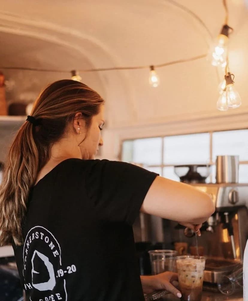 A Cornerstone Coffee barista pouring a drink at the mobile coffee bar