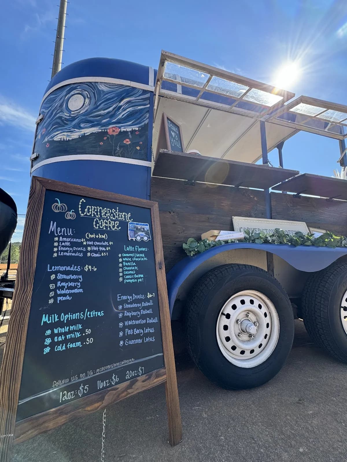 Cornerstone Coffee's trailer and hand-lettered chalkboard menu under bright sun at an outdoor event