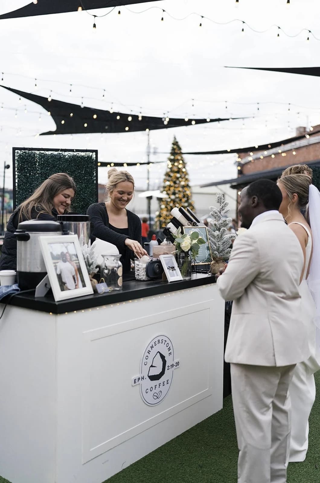 Cornerstone Coffee's bar serving guests at an evening holiday event under string lights