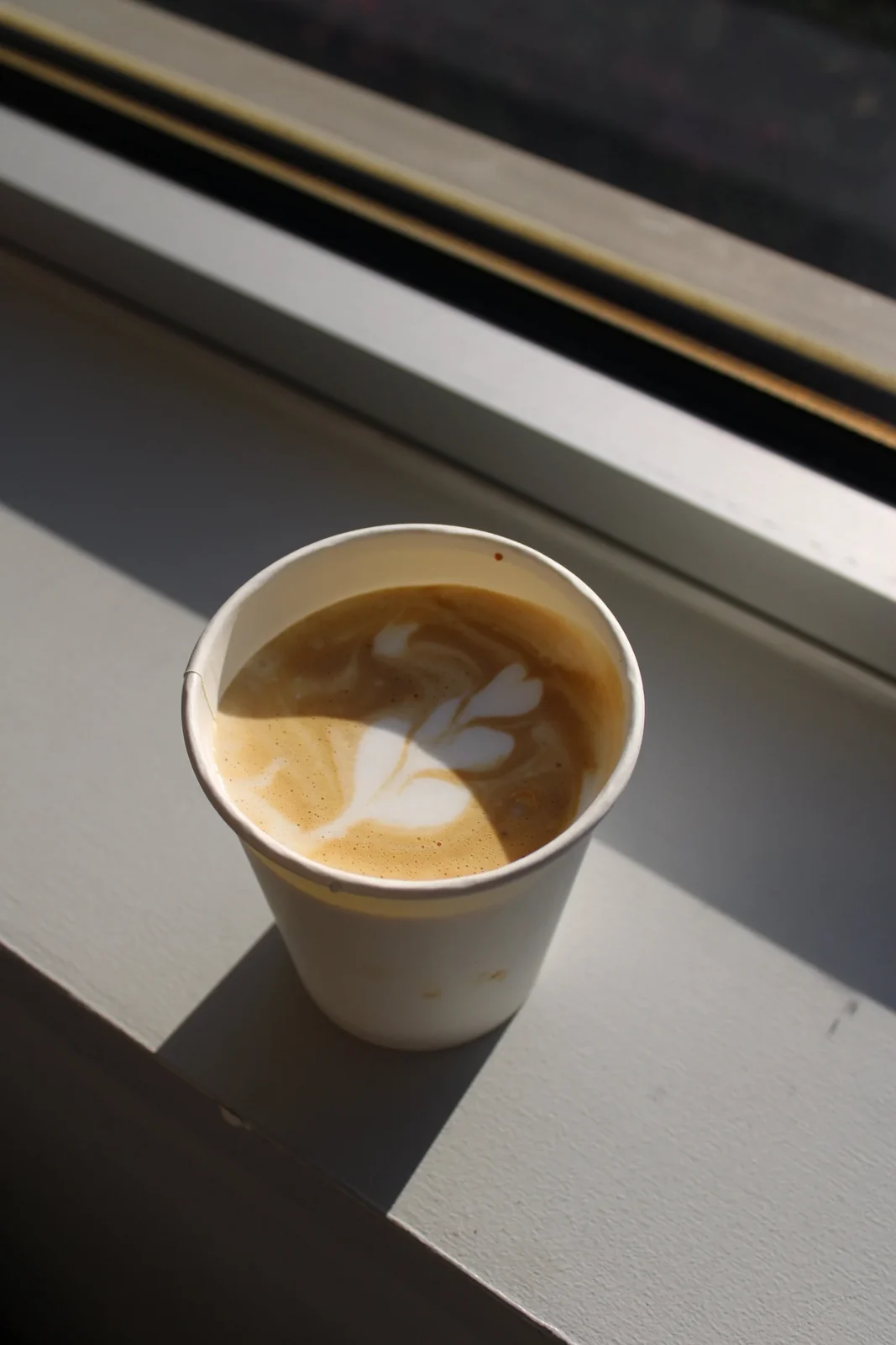 A freshly poured latte with latte art in a Cornerstone Coffee cup