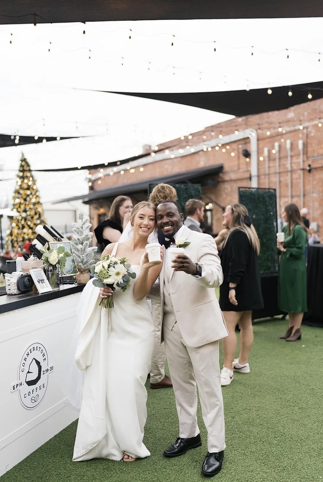 Newlyweds toasting with coffee at the Cornerstone Coffee bar during an evening wedding reception