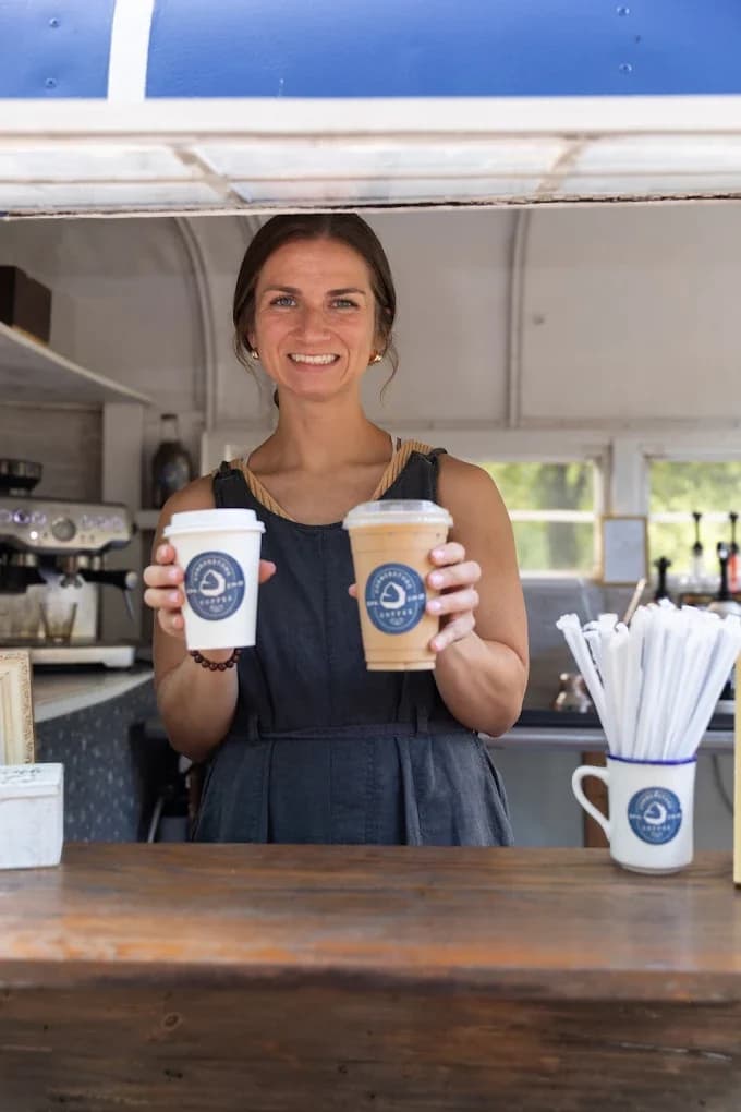 Two branded Cornerstone Coffee cups held up at an event
